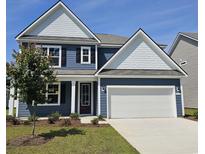 Two-story home with navy siding, white accents, a two-car garage, and a well-maintained lawn at 566 Haven View Way, Murrells Inlet, SC 29576