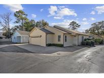 Tan house with attached garage and well-manicured landscaping at 605 Cedar Ln., North Myrtle Beach, SC 29582