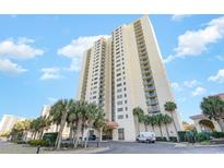 Beautiful high-rise condo building featuring an inviting entrance and lush palm tree landscaping at 8560 Queensway Blvd. # 1210, Myrtle Beach, SC 29572