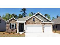 Brick and stone front elevation, three-car garage, and landscaping at 920 Belle Dr., North Myrtle Beach, SC 29582