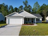 Newly constructed home with a white garage door and landscaping at Tbd11 Casey Dr., Green Sea, SC 29545