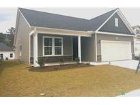 Charming exterior of a one-story home featuring a covered porch and attached garage at 1099 Nw Forest Bend Dr., Calabash, NC 28467