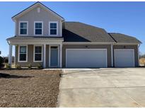 Charming two-story home featuring a three-car garage and a well-manicured lawn at 243 Letha Dr, Longs, SC 29568