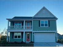 Two-story house with a light green exterior, red door, and front porch at 390 Glacier Way, Conway, SC 29526