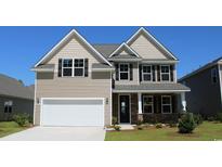 Two-story house with a neutral color scheme, white garage door, and landscaping at 400 Clear Lake Dr., Conway, SC 29526