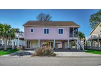 Charming elevated beach house with pink siding, covered parking, and a screened-in porch at 403 20Th Ave. N, North Myrtle Beach, SC 29582