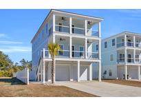 Two-story light blue house with white trim, two-car garage, and a palm tree in the front at 434 Stanley Dr., Murrells Inlet, SC 29576