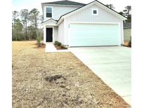 Two-story house with attached garage and landscaped yard at 447 Ribbon Rail Way, Loris, SC 29569