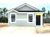 Newly constructed home featuring gray siding, a black front door, and a small front yard at 467 Ribbon Rail Way, Loris, SC 29569