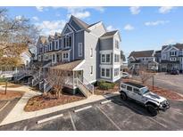 Three-story townhome with gray siding, multiple balconies, and ample parking at 4999 Highway 17 Business # 108 D, Murrells Inlet, SC 29576