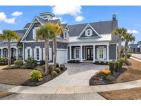 Charming home featuring a beautiful yard, inviting front entrance, attached garage and palm tree landscaping at 5960 Bolsena Place, Myrtle Beach, SC 29577