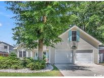 Attractive light beige house with two-car garage and landscaping at 600 N 17Th Ave. N, Surfside Beach, SC 29575