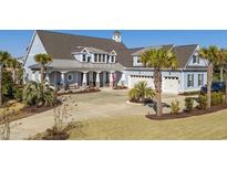 Two-story house with a large driveway and palm trees in the front yard at 6025 Bolsena Place, Myrtle Beach, SC 29577