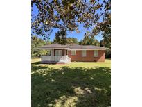 Charming brick home featuring a covered porch and a well-maintained lawn at 7195 Hwy 9, Nichols, SC 29581