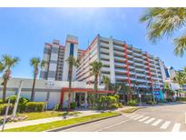 Inviting condo exterior with palm trees, colorful accents, well-manicured lawn, and beach access at 7200 N Ocean Blvd. # 314, Myrtle Beach, SC 29572