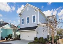 Charming home showcasing light blue siding, a two-car garage, and meticulously maintained landscaping at 822 Farrow Pkwy., Myrtle Beach, SC 29577