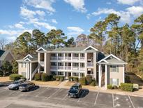 Two-story condo building with ample parking and mature trees at 1125 Blue Stem Dr. # 29-H, Pawleys Island, SC 29585