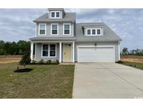 Charming two-story home featuring a yellow front door, a two-car garage, and a well-manicured lawn at 140 Joyce Dr, Longs, SC 29568