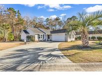 Attractive house exterior with a large driveway and palm trees at 1501 Saint George Ln., Myrtle Beach, SC 29588
