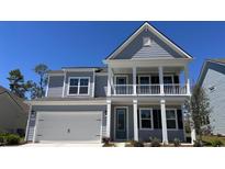 Charming two-story home with a covered porch and a two-car garage, painted in light and dark shades of gray at 1828 Hardwood Ct., Conway, SC 29526