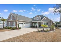 Two-story home with a three-car garage and landscaped yard at 1853 Wood Stork Dr., Conway, SC 29526