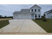 Charming two-story home featuring a two-car garage, light blue door, and a concrete driveway leading to a spacious front yard at 251 Letha Dr, Longs, SC 29568