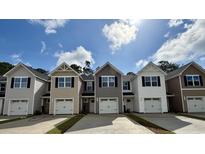 View of newly constructed townhomes with gray siding, white trim, and single-car garages on a sunny day at 265 Christiana Ln. # D, Myrtle Beach, SC 29579