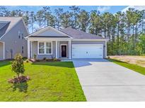 Charming single-story home featuring a manicured lawn and a two-car garage at 409 Sun Colony Blvd., Longs, SC 29568