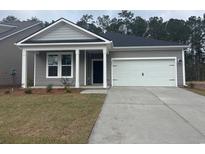 Charming single-story home with a gray exterior, a two-car garage, and a well-manicured lawn at 409 Sun Colony Blvd., Longs, SC 29568