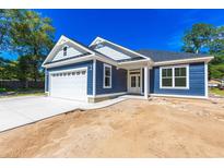 Newly built home featuring a blue exterior, white garage door, and a spacious front yard at 4090 Lake Shore Dr., Little River, SC 29566