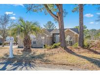 Charming brick home with well-manicured landscaping, mailbox, and mature trees providing shade at 4110 Fairway Dr., Little River, SC 29566