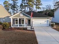 Charming single-story home with well-maintained landscaping, two-car garage, and inviting front porch at 440 Craigflower Ct., Longs, SC 29568