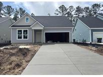 Charming single-story home with gray siding, gray roof, and spacious driveway leading to a two-car garage at 456 Sun Colony Blvd., Longs, SC 29568