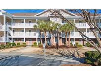Two-story condo building with balconies and palm trees at 5825 Catalina Dr. # 332, North Myrtle Beach, SC 29582