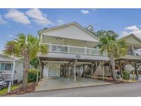 Elevated beach house with wrap-around porch and parking underneath at 6001-1830A S Kings Highway, Myrtle Beach, SC 29575