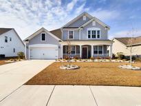 Charming two-story home featuring a welcoming front porch and well-maintained landscaping at 656 Hickman St., Surfside Beach, SC 29575