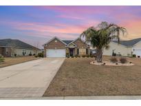 Brick home with two-car garage and landscaped yard at 700 Harbor Bay Dr., Murrells Inlet, SC 29576