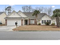 Charming single-story home with a brick facade, a two-car garage, and a well-manicured lawn at 720 Dove Haven Ln., Myrtle Beach, SC 29579