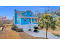 Charming two-story blue home with white trim, garage, and a welcoming front porch at 74 Marsh Point Dr., Pawleys Island, SC 29585