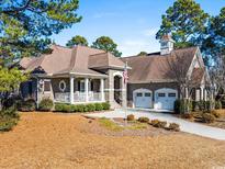 Brick home with a three-car garage and a large front porch at 7403 Haddington Pl., Sunset Beach, NC 28468