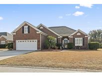 Charming brick home featuring a well-manicured lawn, attached garage, and inviting front entrance at 116 Cypress Estates Dr., Murrells Inlet, SC 29576