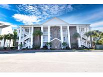 Three-story condo building with brick facade, white columns, staircases, and parking at 118 Birch N Coppice Dr. # 3, Surfside Beach, SC 29575