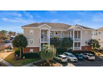 Beautiful condo building featuring outdoor balconies, parking, and lush landscaping on a sunny day at 1538 Lanterns Rest Rd. # 103, Myrtle Beach, SC 29579