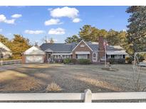 Charming brick home with a manicured lawn, attached garage, and inviting curb appeal at 1817 South Island Rd., Georgetown, SC 29440