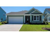 Charming green house with a white garage door and landscaped lawn at 1844 Hardwood Ct., Conway, SC 29526