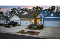 Three-unit townhome building, featuring two-car garages and neutral-color siding at 2475 Blue Crane Circle # 104, Myrtle Beach, SC 29577