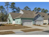 Charming townhome featuring attached garages, craftsman style doors, and nicely landscaped front yard at 2539 Blue Crane Circle # 101, Myrtle Beach, SC 29577