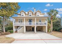 Charming stilt home featuring three dormers, a large front porch, and ample parking at 438 Cayman Loop, Pawleys Island, SC 29585