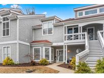 Charming two-story condo featuring gray shingles, red accents, and a welcoming front entrance with a cozy balcony at 4396 Baldwin Ave. # 94, Little River, SC 29566