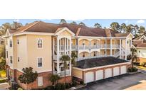 Multi-level condo building with garages, balconies and stucco siding at 4872 Dahila Ct. # 103, Myrtle Beach, SC 29577